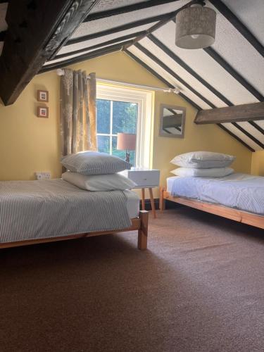 una camera da letto con due letti e una finestra di Sparrows Nest Holiday Cottage ad Amroth