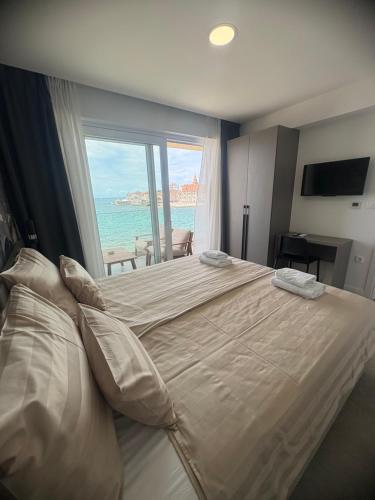 a bedroom with a large bed with a view of the ocean at Calypso Residence in Umag