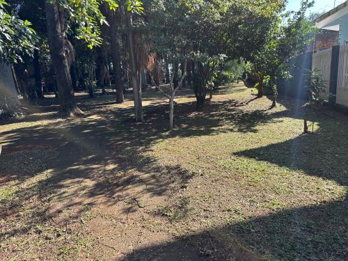 a yard with trees and grass and a fence at Recanto Luna in Foz do Iguaçu