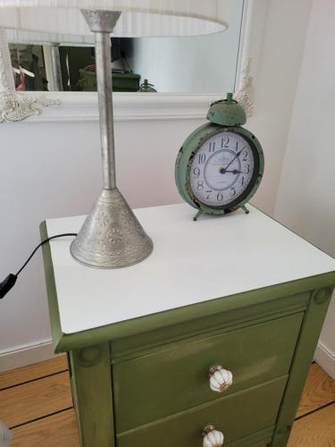 a clock on a dresser with a lamp on it at Villa Ekegården in Härryda