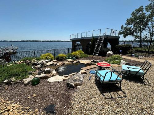 a patio with two chairs and a bridge over a body of water at Driftwood Dreams in Chapin