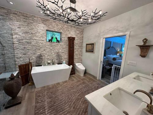 a bathroom with a tub and two sinks and a toilet at Driftwood Dreams in Chapin