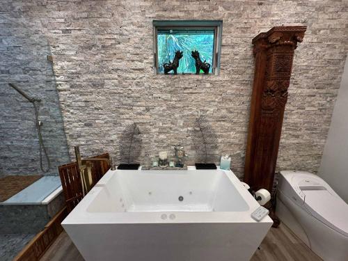 a white bath tub in a bathroom with a window at Driftwood Dreams in Chapin