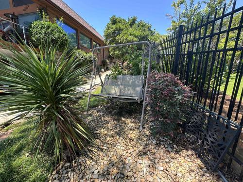 a garden with a chair next to a fence at Driftwood Dreams in Chapin