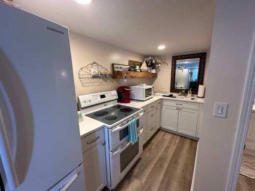 a kitchen with white cabinets and a stove top oven at Driftwood Dreams in Chapin