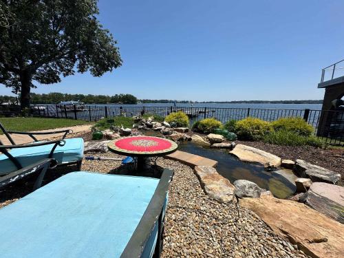 a patio with a table and a bench and a pond at Driftwood Dreams in Chapin