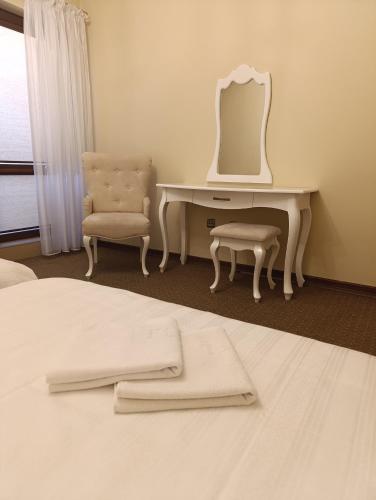 a bedroom with a desk with a mirror and a chair at Villa Roma in Miedzierza