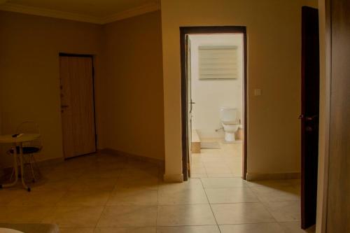 an empty room with a toilet and a door at Pot of Gold East Legon in Accra