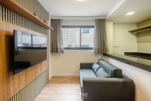 a living room with a couch and a flat screen tv at Prédio c/ Aptos Novos a 300m da Praia - EEP in Guarapari