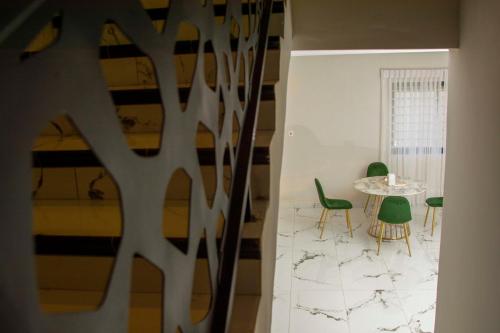 a dining room with a table and green chairs at Pot of Gold East Legon in Accra