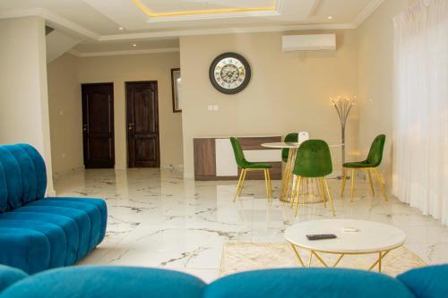 a living room with a blue couch and green chairs at Pot of Gold East Legon in Accra