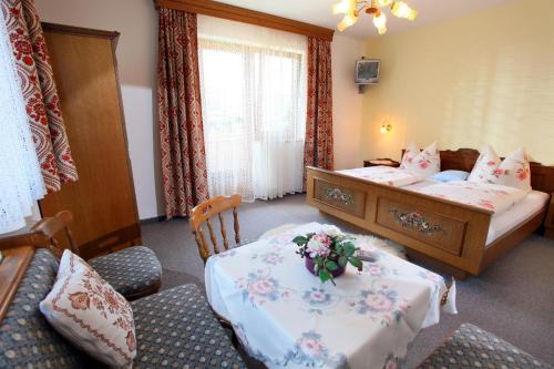 a bedroom with two beds and a table with flowers on it at Rosenhof in Bichling
