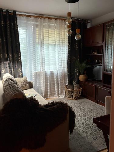 a living room with a white couch and a window at Przytulny Apartament in Ostrowiec Świętokrzyski
