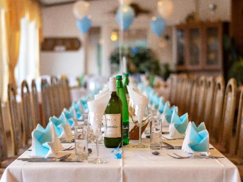 a long table with a bottle of wine and glasses at Gostisce Golob in Zgornja Polskava