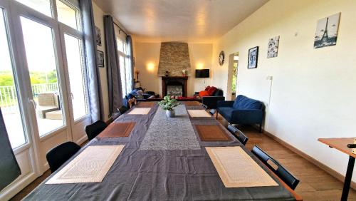 a long long table in a room with a fireplace at Appart 10personnes Terrasse vue Loire, Parkings Voitures Vélos,10min Centre Blois,40min Zoo Beauval in Blois