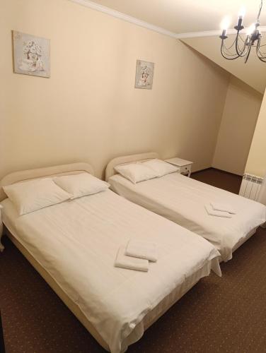 two beds sitting next to each other in a room at Villa Roma in Miedzierza