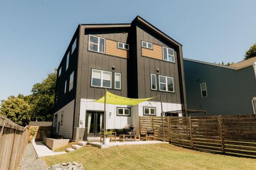 a black and white house with a fence at ModTrio 3BR with ensuites & Garage Mins to Uptown in Charlotte