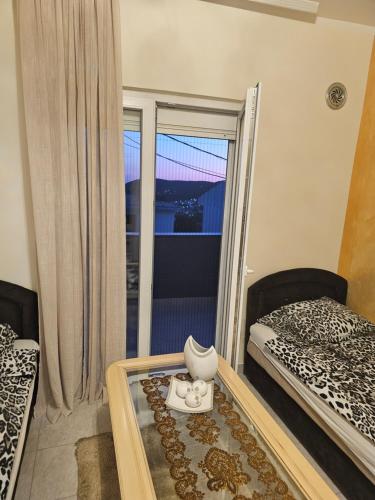 a room with a bed and a table with a window at Apartmani Sabotic in Sutomore