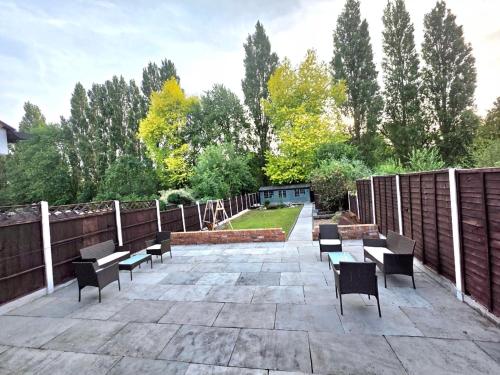 a patio with benches and tables and a fence at Stunning property with Summer house in Bescot