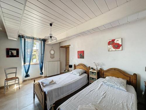 a bedroom with two beds and a chair at Ferme Gascone proche Marciac in Bars