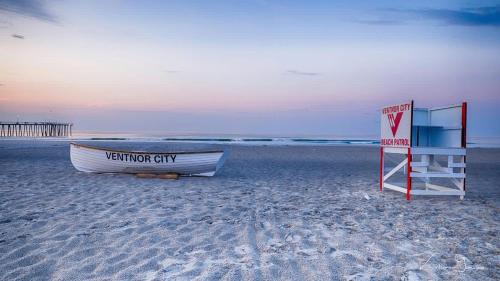 a boat and a sign on the beach at Ammos Luxury Living- Naxos Suite in Ventnor City