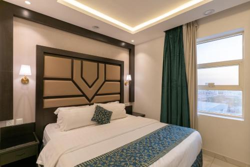 a bedroom with a large bed and a window at Gardenia Park Al Rawabi Serviced Apartments Economyجاردنيا بارك الروابي للشقق المخدومةاقتصادي in Quwayzah