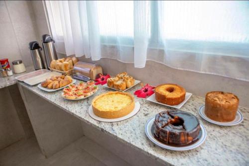 a counter topped with different types of cakes and pastries at Pousada Além dos Mares in Fernando de Noronha
