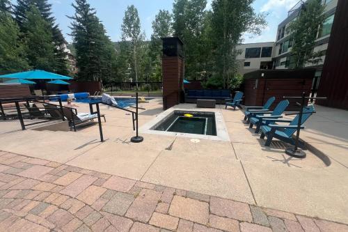 a pool with chairs and a table and an umbrella at Vail Spa 301 in Vail