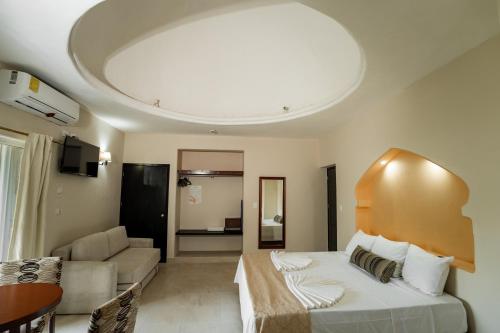 a hotel room with a bed and a living room at Gran SAHARA in Playa del Carmen