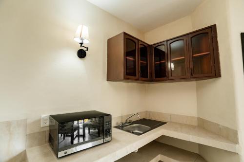 a kitchen with a sink and a microwave at Gran SAHARA in Playa del Carmen