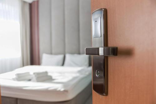 a room with a bed and a door with a door knob at Hotel Europejski in Nysa