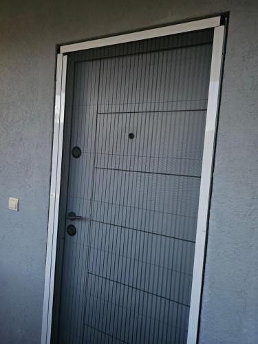 a glass door with two metal spheres on it at Apartmani Sabotic in Sutomore