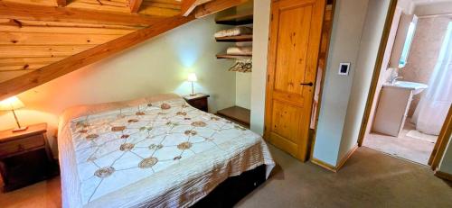 Un dormitorio con una cama en una habitación con techos de madera. en Casa Barrio La Colina 15 pax, en San Carlos de Bariloche