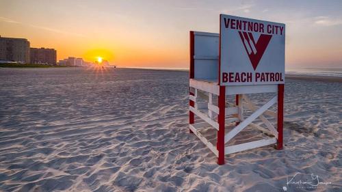 a sign on the beach with the sunset in the background at Ammos Luxury Living- Paros Suite in Ventnor City
