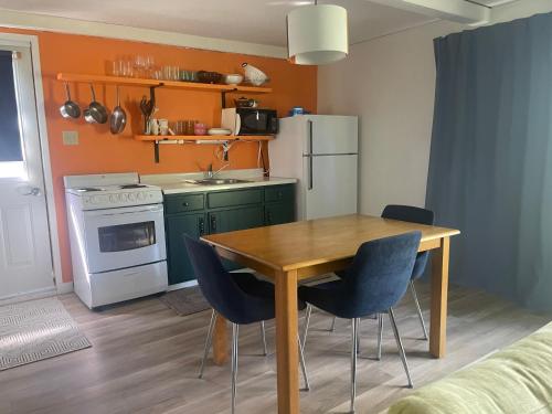 a kitchen with a wooden table and blue chairs at Colonial Bay Motel and Cottages in Huntsville