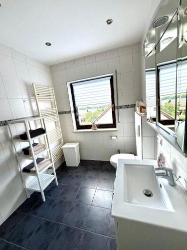 a bathroom with a sink and a toilet and a window at Ferienwohnung-Charly in Mettlach