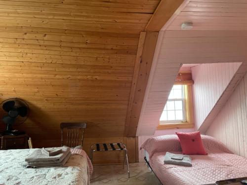 a bedroom with a bed in a wooden room at La Forillonne in Gaspé
