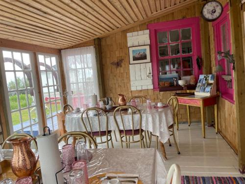 a dining room with tables and chairs and a clock at La Forillonne in Gaspé