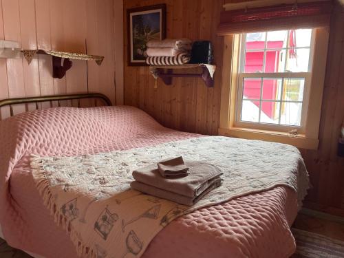 a bedroom with a bed with towels on it at La Forillonne in Gaspé