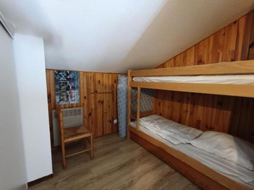 Ce lit se trouve dans un dortoir doté de 2 lits superposés et de murs en bois. dans l'établissement Résidence Ferme D'augustin - Batiment C - Grand duplex pour 6 personnes - Skis aux pieds MAE-8904, à Montgenèvre