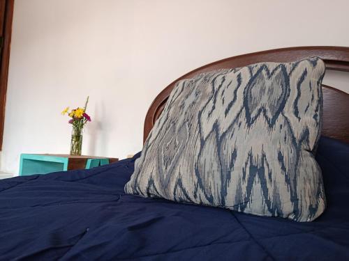 a pillow on a bed with a blue comforter at Che Parce in Samaipata