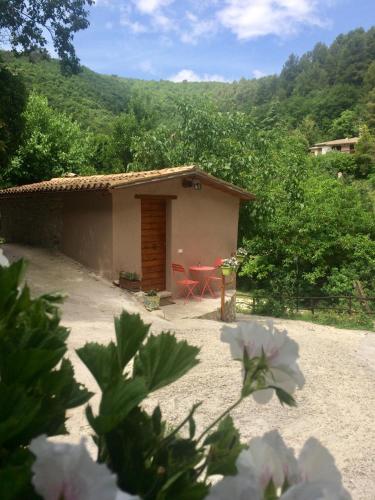 a small house with a table and chairs in a yard at la casetta delle more (monolocale) in Spoleto