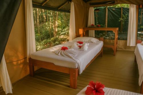 a bedroom with a bed with flowers on it at La Leona Eco Lodge in Carate