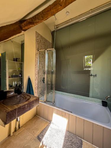 a bathroom with a tub and a glass shower at The Barn in Highbridge