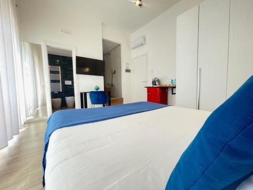 a bedroom with a large white bed and a kitchen at Duomo Rooms - Manfredi Homes&Villas in Manfredonia
