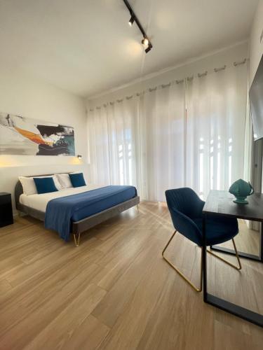 a bedroom with a bed and a table and a chair at Duomo Rooms - Manfredi Homes&Villas in Manfredonia