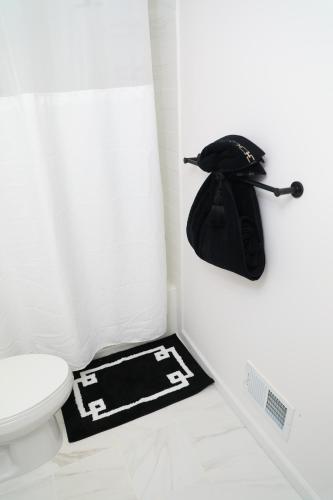 a bathroom with a toilet and a hat on the floor at Modern Minimalist Lux Paradise in Newark