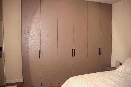 a bedroom with brown cabinets next to a bed at Greco Boutique Hotel in Shkodër