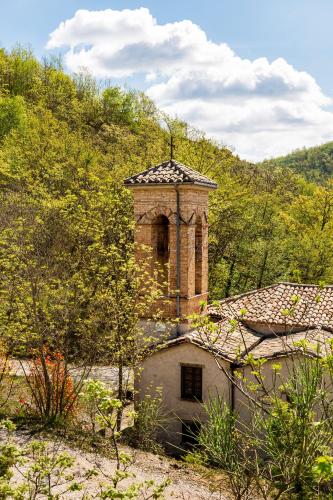 an old brick building with a tower on top of it at Tenuta Borgo Santa Cecilia in Gubbio