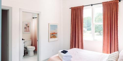 a bathroom with a bed and a toilet and a window at ModTrio 3BR with ensuites & Garage Mins to Uptown in Charlotte